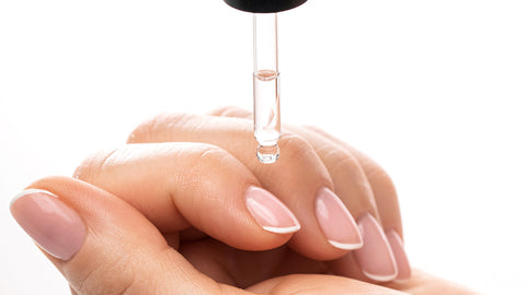 Cuticle oil applied with a dropper to natural nails