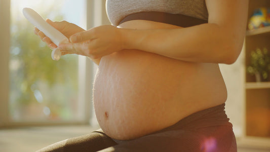 Pregnant woman applying moisturiser