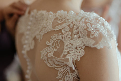 Close detail of lace on the shoulder of a wedding dress