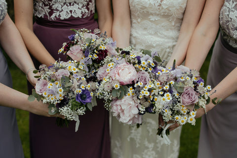 Bridesmaids in matching dresses holding a bouquet of flowers