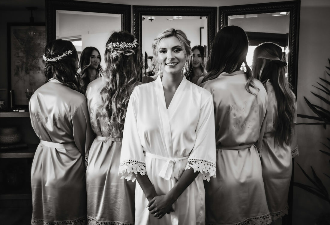 A bride in a robe with her bridesmaids getting ready before the wedding