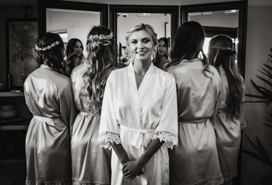 A bride in a robe with her bridesmaids getting ready before the wedding